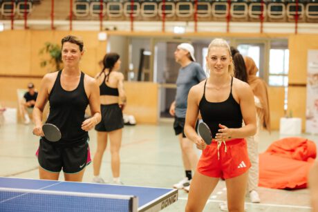 Manuela Stöckl und Magdalena Rauter stehen mit ihren Schlägern beim Tischtennis-Tisch und spielen ein Doppel.