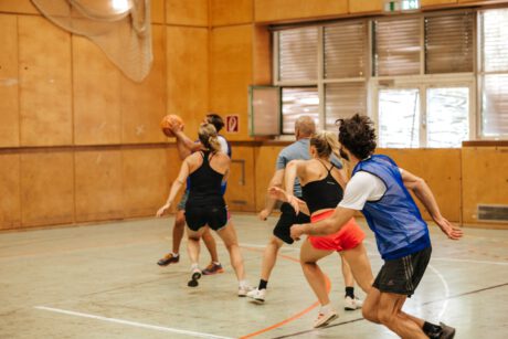 Fünf Spieler:innen kämpfen um den Basketball beim 3x3 und laufen auf den Korb zu.