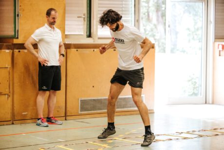 Schauspieler Aaron Karl trippelt durch eine Koordinationseiter am Boden beim Geschicklichkeitsparcours.