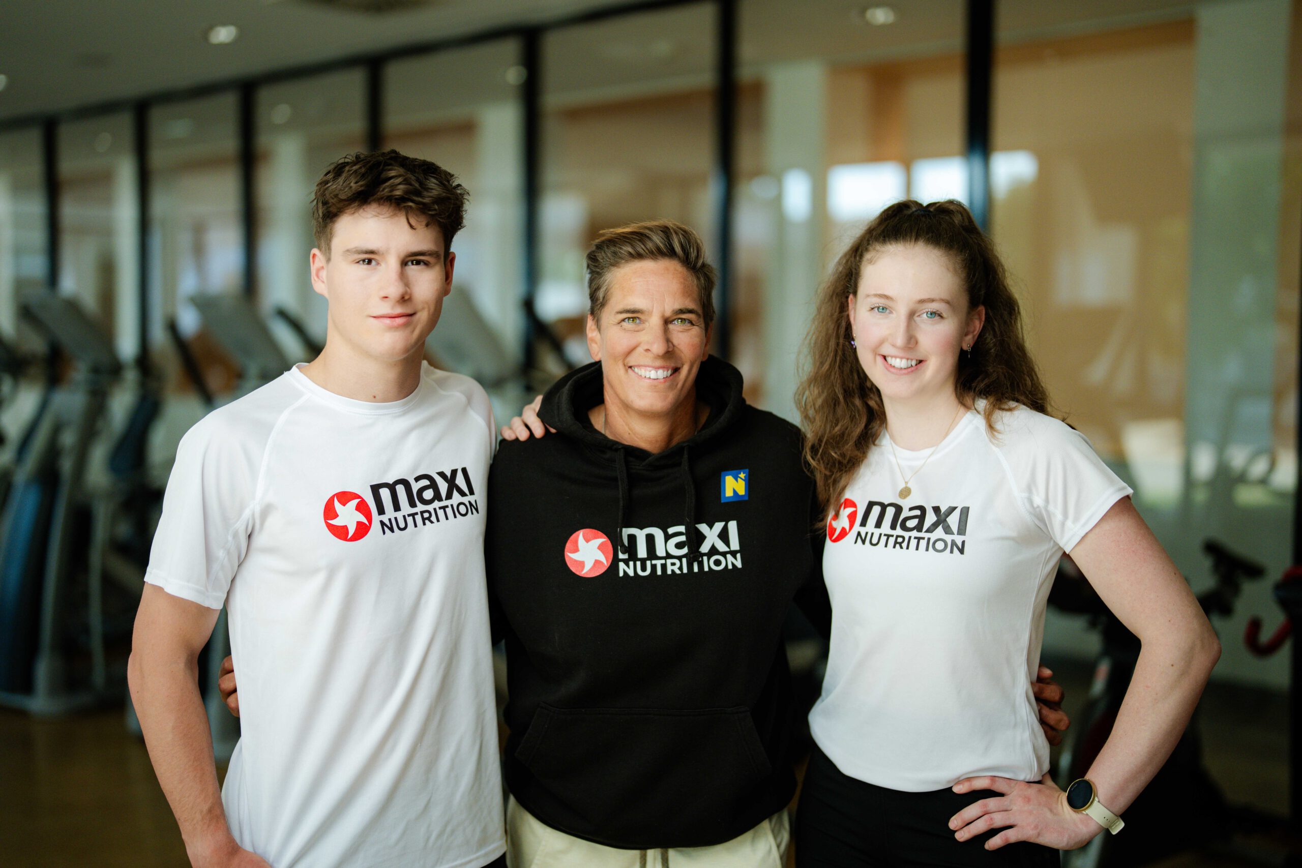 Elias Eischer, Michaela Dorfmeister und Angelika Dallhammer lächeln in der Halbtotalen in die Kamera. Elias & Angelika tragen ein Kurzarm-Shirt und Michi in der Mitte einen kuscheligen Pullover.