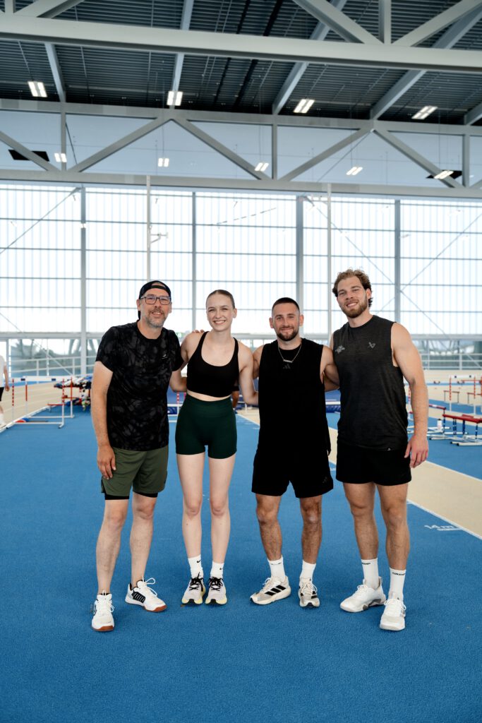 Stefan Konvicka, Caroline Guttmann, Christian Szalay und Patrick Peter stehen auf einer Laufbahn, halten sich in den Armen und lächeln in die Kamera für ein Gruppenbild.