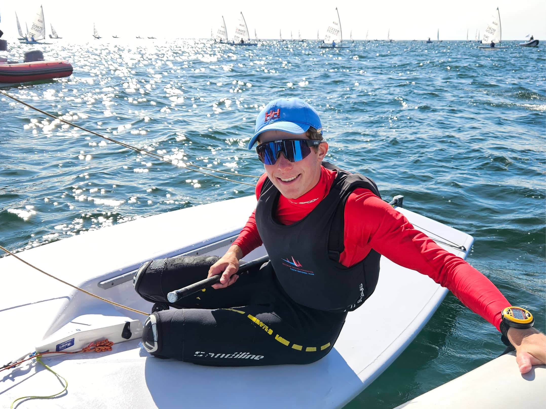 Anton Messeritschin einem Neoprenanzug und mit Schwimmbrille sitzt auf einem Segelboot.