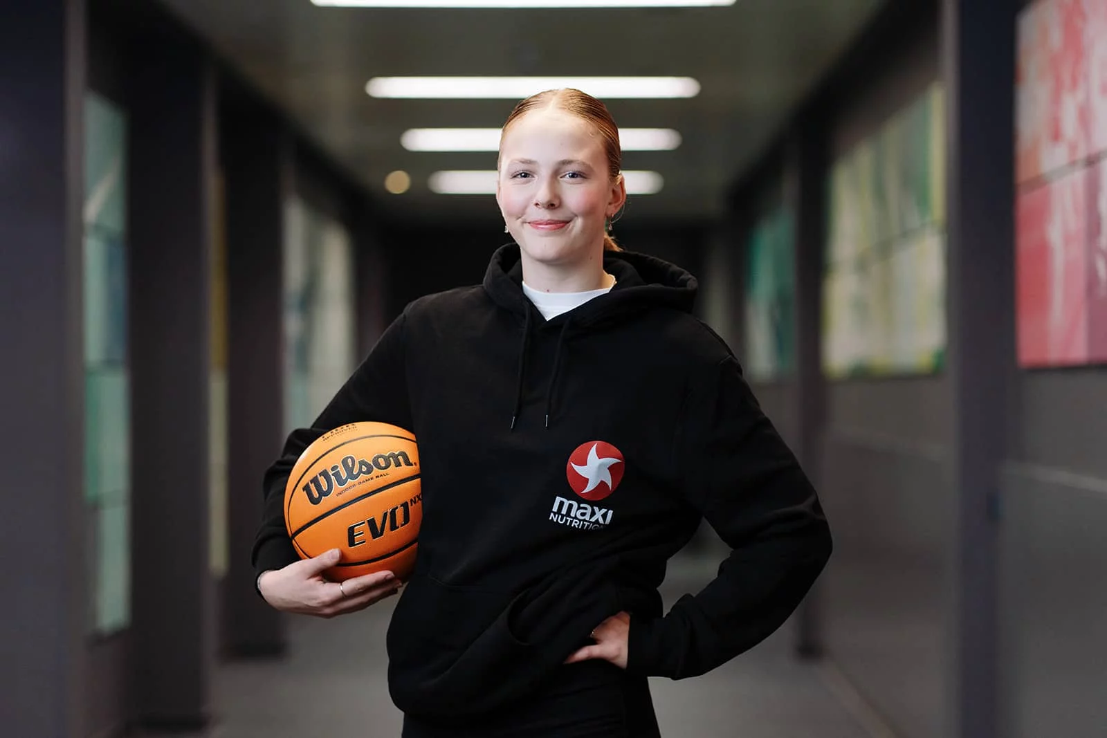 Sina Höllerl steht mit einem Basketball